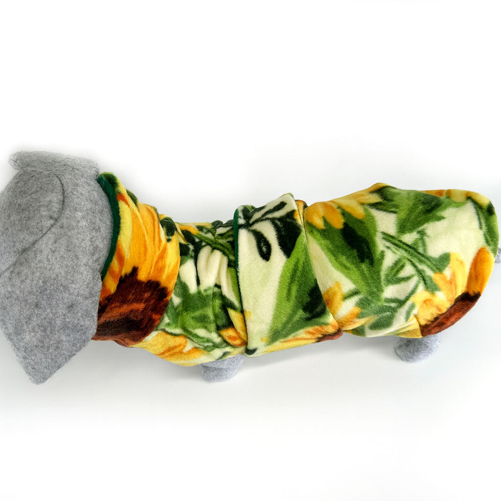 Top view of a floral sun flower patterned dog coat on a  grey mannequin . Against  a white background. Gives the view of what the top of the dog coat looks like